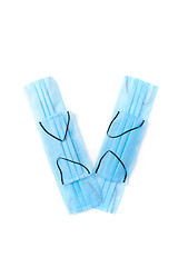 Image showing Letter V made from protective medical masks on a white background.