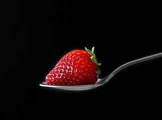 Image showing fresh ripe strawberry on black background