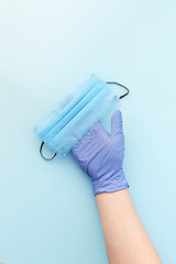 Image showing Medical mask on a woman\'s hand in protective rubber glove. Top view.