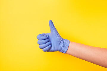 Image showing Sign OK made of woman\'s hand in rubber protective glove.