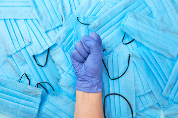 Image showing Woman clenched fist in a rubber protective glove on a medical ma