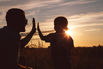 Image showing Father and son playing in the park at the sunset time.