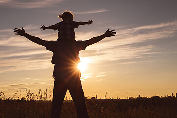 Image showing Father and son playing in the park at the sunset time.