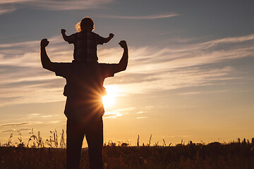 Image showing Father and son playing in the park at the sunset time.