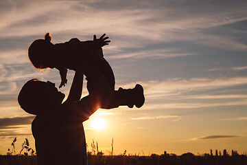 Image showing Father and son playing in the park at the sunset time.