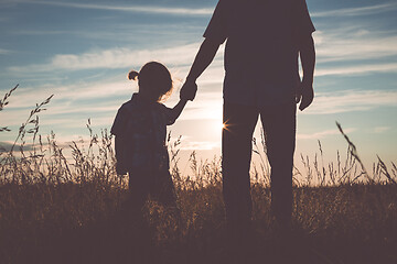 Image showing Father and sad son standing in the park at the sunset time.