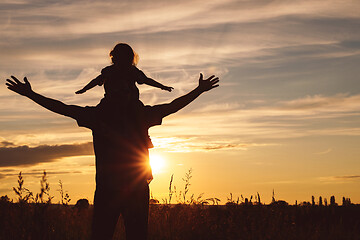 Image showing Father and son playing in the park at the sunset time.