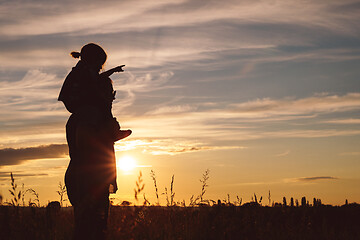 Image showing Father and son playing in the park at the sunset time.