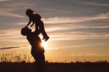 Image showing Father and son playing in the park at the sunset time.