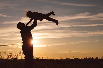 Image showing Father and son playing in the park at the sunset time.