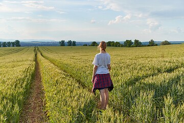 Image showing Green field and a girl standing on it