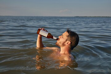 Image showing Summer beach drinking beer and swimming