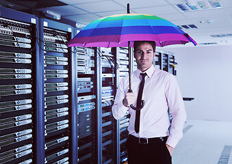 Image showing businessman hold umbrella in server room