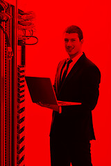 Image showing businessman with laptop in network server room