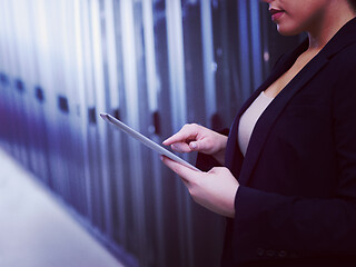 Image showing Female engineer working on a tablet computer in server room