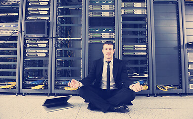 Image showing businessman with laptop in network server room