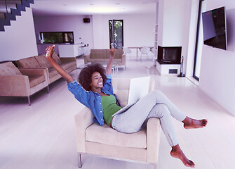 Image showing African American women at home in the chair using a laptop