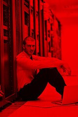 Image showing businessman with laptop in network server room