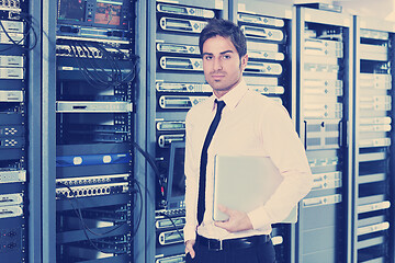 Image showing businessman with laptop in network server room