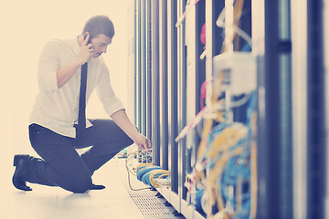 Image showing it engeneer talking by phone at network room