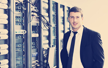 Image showing businessman with laptop in network server room