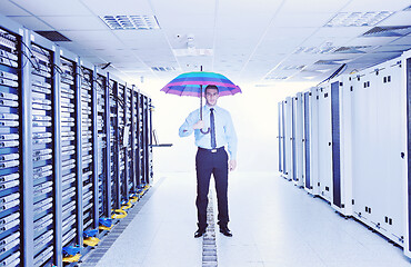 Image showing businessman hold umbrella in server room