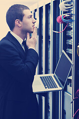 Image showing businessman with laptop in network server room