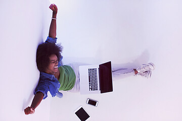 Image showing african american woman sitting on floor with laptop top view