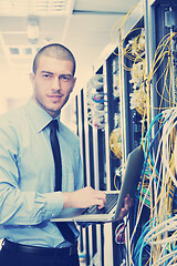 Image showing businessman with laptop in network server room