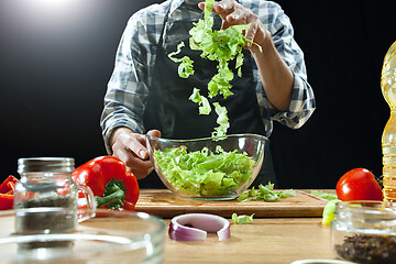 Image showing Preparing salad. Female chef cutting fresh vegetables. Cooking process. Selective focus