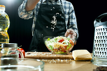 Image showing Preparing salad. Female chef cutting fresh vegetables. Cooking process. Selective focus