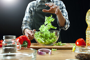 Image showing Preparing salad. Female chef cutting fresh vegetables. Cooking process. Selective focus