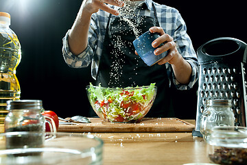 Image showing Preparing salad. Female chef cutting fresh vegetables. Cooking process. Selective focus