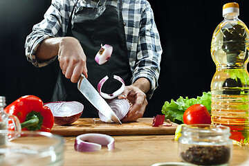 Image showing Preparing salad. Female chef cutting fresh vegetables. Cooking process. Selective focus