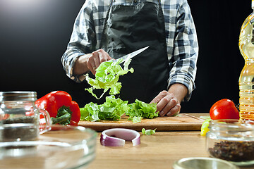 Image showing Preparing salad. Female chef cutting fresh vegetables. Cooking process. Selective focus