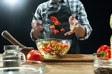 Image showing Preparing salad. Female chef cutting fresh vegetables. Cooking process. Selective focus