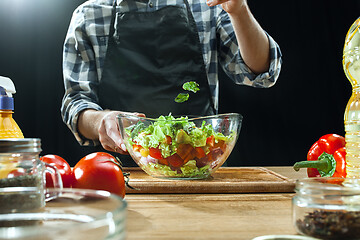 Image showing Preparing salad. Female chef cutting fresh vegetables. Cooking process. Selective focus