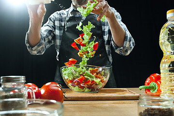 Image showing Preparing salad. Female chef cutting fresh vegetables. Cooking process. Selective focus