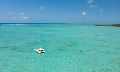 Image showing Catamaran sailing boat in turquoise sea lagoon on tropial Mauritius island. Aerial, drone view.