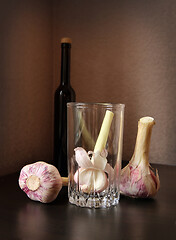 Image showing Three garlic bulbs and bottle