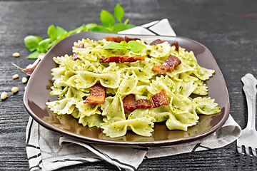 Image showing Farfalle with pesto and bacon on wooden board