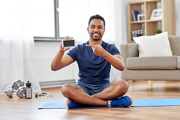 Image showing indian man with smartphone on exercise mat at home