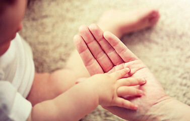 Image showing close up of little baby and mother hands
