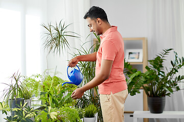 Image showing indian man watering houseplants at home