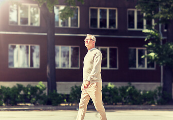 Image showing senior man walking along summer city street