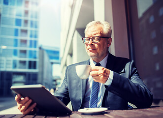 Image showing senior businessman with tablet pc drinking coffee