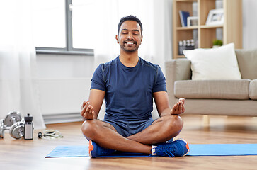 Image showing indian man meditating in lotus pose at home