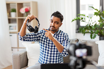 Image showing male blogger with headphones videoblogging at home