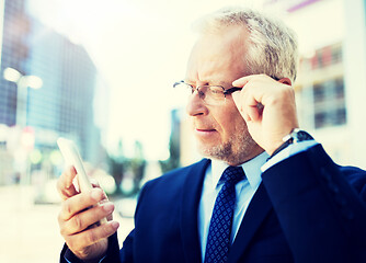 Image showing senior businessman with smartphone in city