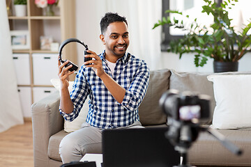 Image showing male blogger with headphones videoblogging at home